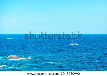 The sailboat floats in the sea.