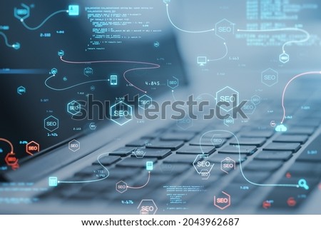 Close up of laptop with abstract glowing SEO interface with icons on blurry background. Search engine optimization and coding concept. Double exposure