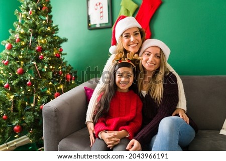 Multiracial happy family looking at the camera and smiling for a picture while celebrating Christmas at home