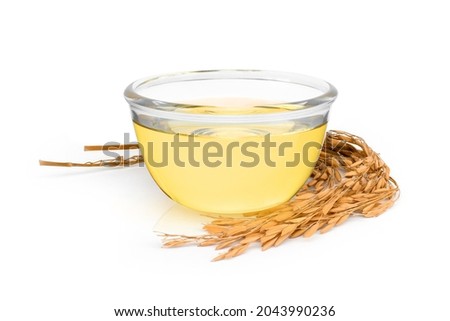 Rice bran oil extract with paddy unmilled rice on white background. Royalty-Free Stock Photo #2043990236