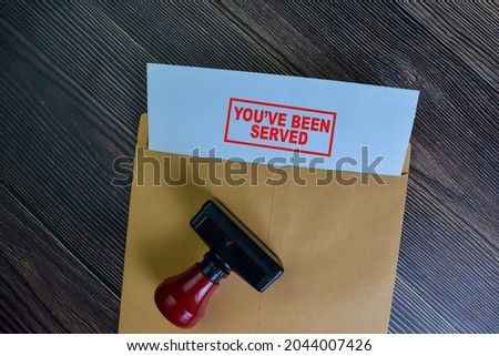 You've Been Served text on document above brown envelope. Royalty-Free Stock Photo #2044007426