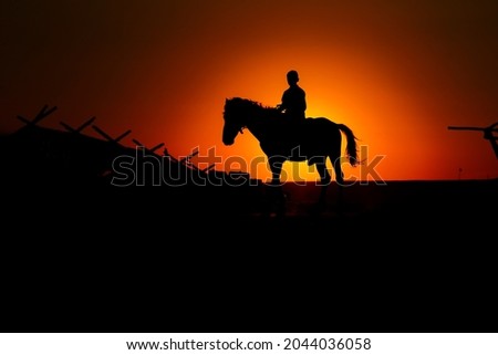 sunset horse and boy. A boy riding a horse and the sunset. horse and boy silhouette.