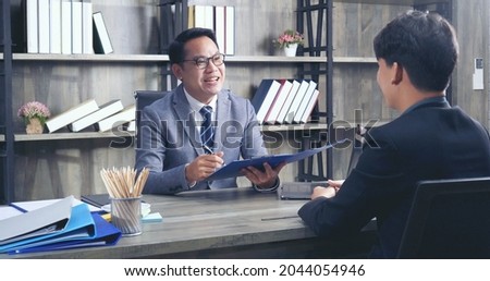 Two Businessman signing contract document start business agreement dealing teamwork. Close up hand young man colleagues  meeting mergers and acquisitions business. Partners Signed document at office.