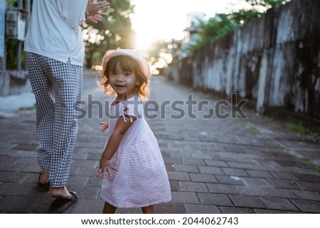 Happy mother and baby walking in city during sunset