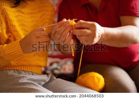 little girl learning to crochet. Yellow color, autumn