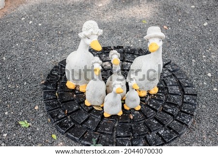 A family statue of a duck on the street
