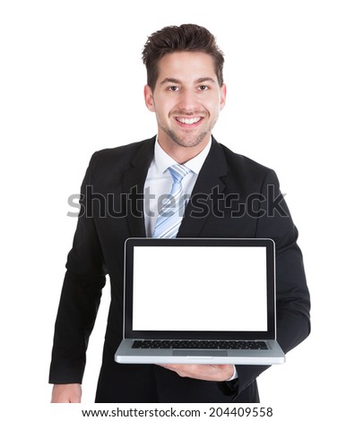 Portrait of confident mid adult businessman displaying laptop over white background