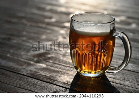 Refreshing fresh draft beer in a dewy glass. Good and honest Czech quality beer on a wooden table background