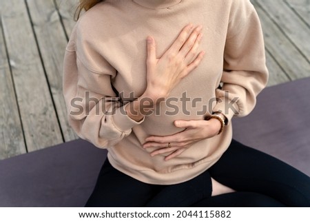 Close-up of a woman's hands on her chest while doing breathing exercises Royalty-Free Stock Photo #2044115882
