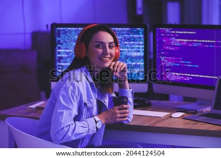 Female programmer working in office at night Royalty-Free Stock Photo #2044124504