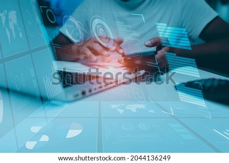 Businessman hands touching on digital smartphone and laptop computer with technology global networking security information and innovation icon virtual screen, Background blurred.