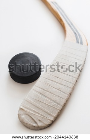Rewound hockey stick and black hockey puck on white background