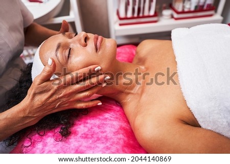Focused photo on brunette woman enjoying massage