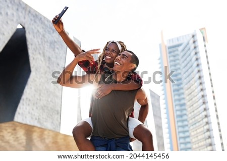 Happy smilng couple taking selfie with phone outdoors. Boyfriend and girlfriend having fun outdoors.	