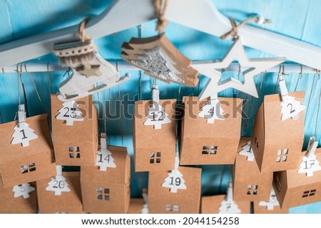 Original Christmas Advent Calendar made of clip, string and cardboard on blue wooden background