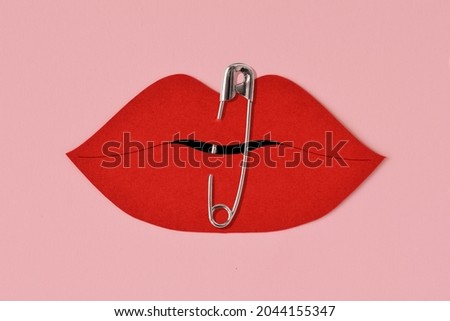 Paper lips cut-out closed with safety pin - Violence against women concept Royalty-Free Stock Photo #2044155347