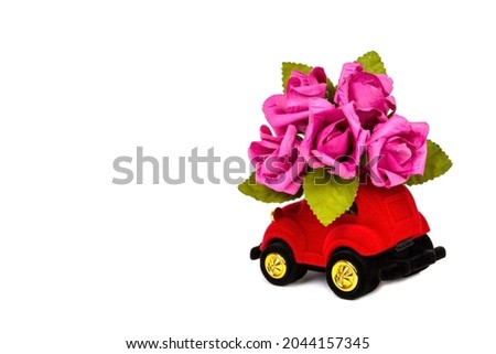red velour toy car delivering bouquet of flowers isolated on white background with copy space. Valentine's day card, birthday, 8 March, International Happy Womens Day