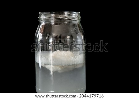 white flour powder dissolving in a bottle of water