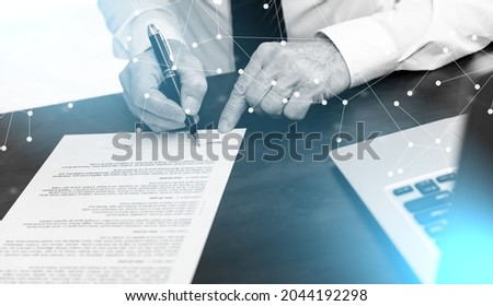 Hand of businessman signing a contract (lorem ipsum text used); light effect