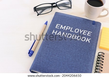 Concept image of employee handbook over wooden office table. top view Royalty-Free Stock Photo #2044206650
