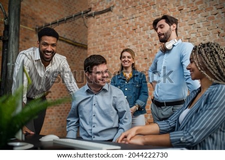 Cheerful young businesspeople having fun in office, social inclusion and cooperation concept. Royalty-Free Stock Photo #2044222730
