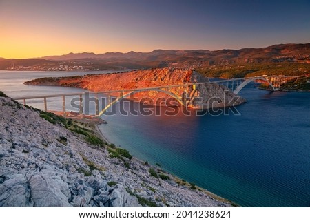 Krk Bridge, Croatia.  Image of Krk Bridge which connects the Croatian island of Krk with the mainland at beautiful summer sunset. Royalty-Free Stock Photo #2044238624