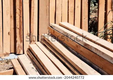 Stack of sawed wooden planks or timber at a construction site. Royalty-Free Stock Photo #2044240772