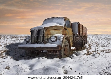 A picture of the old and rusty Soviet truck covered with snow