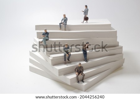 business figure sit on step of paper stack. growth in business concept.