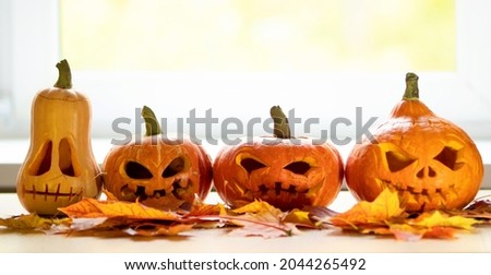Festive halloween pumpkins on a wooden table in front of a window