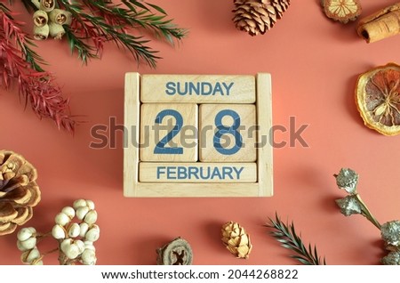 February 28, Cover design with calendar cube, pine cones and dried fruit in the natural concept.