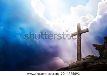 Sky opening up with light rays shining on a cross with doves flying. Religious theme concept. Royalty-Free Stock Photo #2044295693
