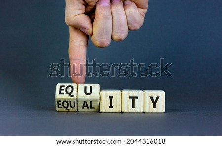 Equity and equality symbol. Businessman turns wooden cubes and changes the word 'equality' to 'equity'. Beautiful grey background. Business, equity and equality concept. Copy space.