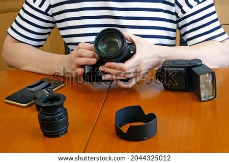 woman photographer making her blog about photo and video camera in kitchen, lens and flash equipment, woman stocker or freelancer, closeup