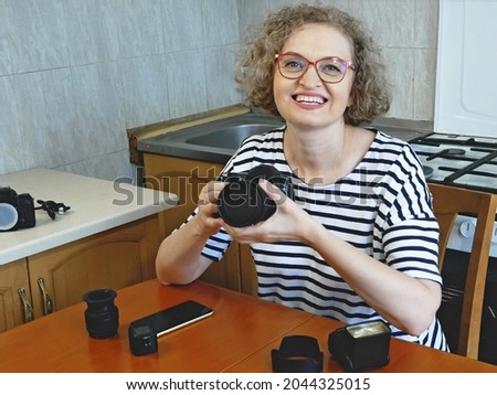 woman photographer making her blog about photo and video camera in kitchen, lens and flash equipment, woman stocker or freelancer, closeup