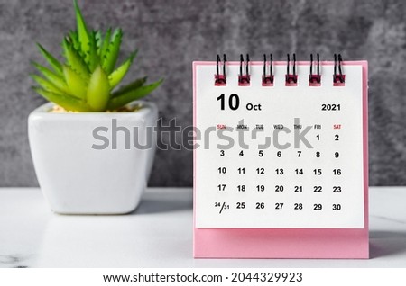 October 2021 desk calendar on wooden table. Royalty-Free Stock Photo #2044329923