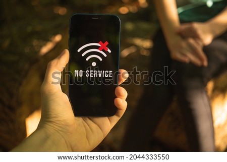 People lost in the woods, searching for help, hand holding mobile phone without cellular coverage, searching for the service or signal concept Royalty-Free Stock Photo #2044333550
