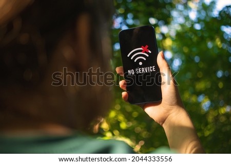 Woman searching for the mobile coverage on the mobile phone, no service screen