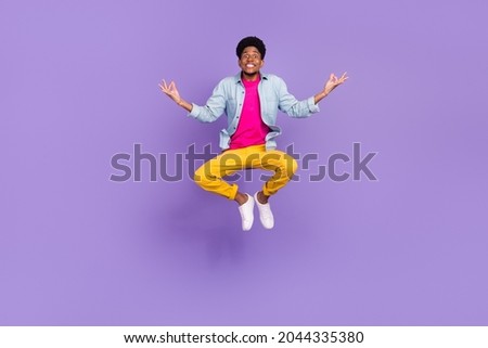 Photo of calm sincere guy jump meditate lotus pose wear blue shirt pants shoes isolated purple color background