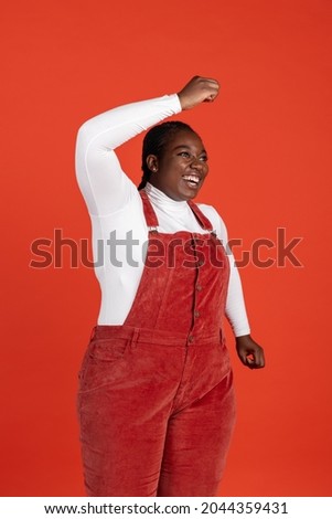 Fun, joy. Bright portrait of African happy woman isolated on red studio background. Concept of human emotions, facial expression, beauty, fashion, youth, sales. Bodypositive and diversity