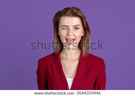 Silly mood. Half-length portrait of young girl isolated on purple, lilac color studio background. Concept of human emotions, facial expression, beauty, fashion, youth, sales.