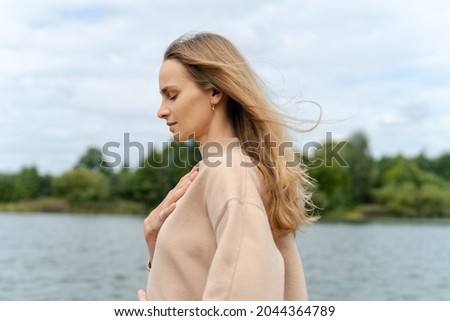 Woman's hand on her chest while doing breathing exercises and meditating. Harmony concept Royalty-Free Stock Photo #2044364789