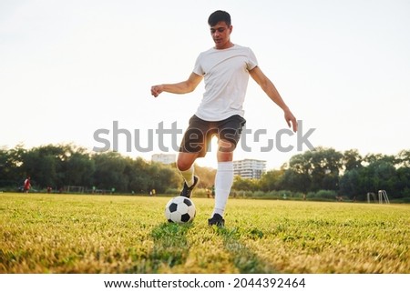 Forest on background. Young soccer player have training on the sportive field. Royalty-Free Stock Photo #2044392464