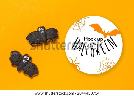 Halloween concept - cookies bats on orange background
