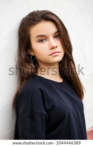 Close up portrait of a young beautiful brunette girl, isolated on white wall background
