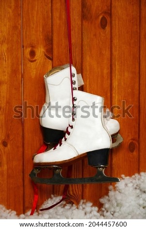 White skates hanging from a nail