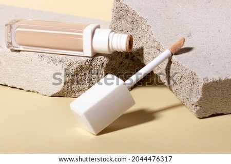 Foundation, concealer on the background of stone geometric shapes. Face corrector on beige background with copy space. Packaging mockup with copy space Royalty-Free Stock Photo #2044476317