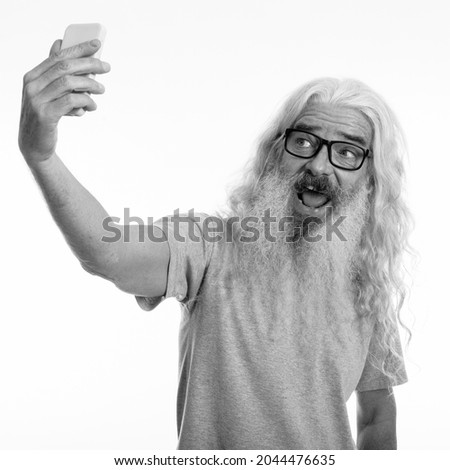 Studio shot of senior bearded man isolated against white background in black and white
