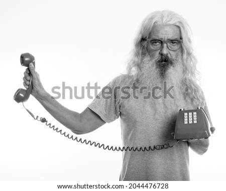 Studio shot of senior bearded man isolated against white background in black and white