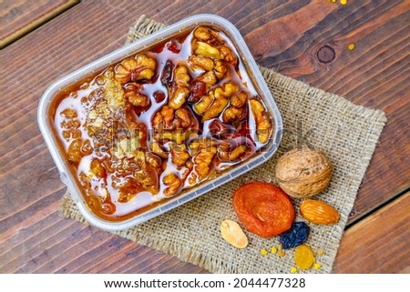 Rustic still life with honey combs  and dried fruits and nuts on a wooden background